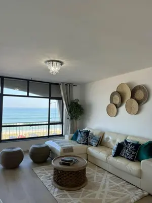 a living room with a couch and a view of the ocean at BEACHFRONT Breeze in Cape Town