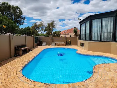 a large swimming pool in a yard with a house at The Seagull in Cape Town