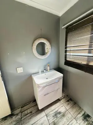 a bathroom with a white sink and a mirror at Zoe & Saint in Cape Town