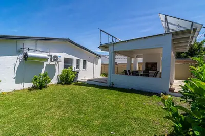 a small house with a balcony and a yard at SeaB by Top Destinations Rentals in Hermanus