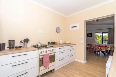 a kitchen with a stove and a dining room at SeaB by Top Destinations Rentals in Hermanus