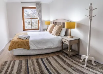 a bedroom with a bed with a cross on it at Village Artisan Franschhoek in Franschhoek