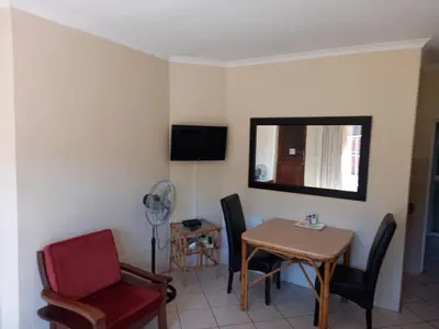 a room with a table and chairs and a mirror at Getaway Self-Catering Panorama in Panorama