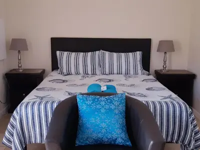a bedroom with a bed with blue shoes on it at Getaway Self-Catering Panorama in Panorama