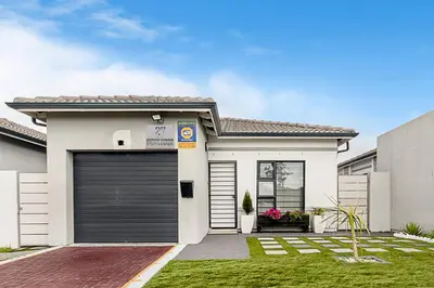 a white house with a garage at The Greenfields Suite in Cape Town