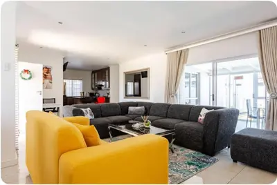 a living room with a couch and yellow chairs at JDBA Homes of Luxury in Cape Town