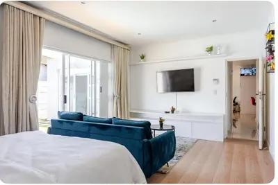 a living room with a blue couch and a tv at JDBA Homes of Luxury in Cape Town