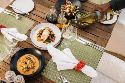 a table with plates of food and a bottle of wine at Birkenhead House in Hermanus