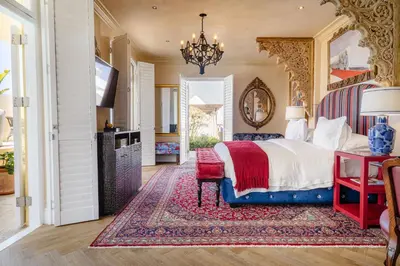 a bedroom with a bed and a tv and a rug at Birkenhead House in Hermanus