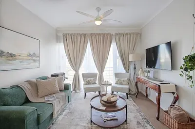 a living room with a green couch and a piano at Unwind at Coral 2BR Bloubergstrand Beach Apt Walk to Beach in Bloubergstrand