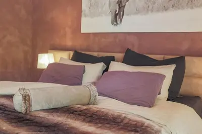 a large bed with pillows on it in a room at YEBO Boutique Guesthouse in Somerset West