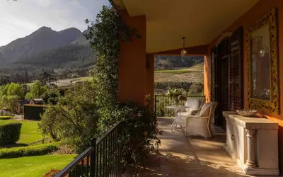 a porch of a house with a view of the mountains at La Residence in Franschhoek