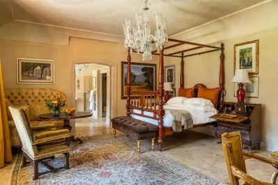 a bedroom with a canopy bed and a table and chairs at La Residence in Franschhoek