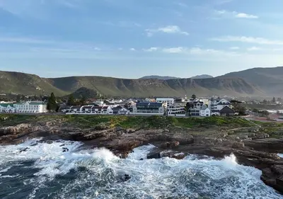 a group of buildings on the shore of the ocean at 111 at The Esplanade in Hermanus