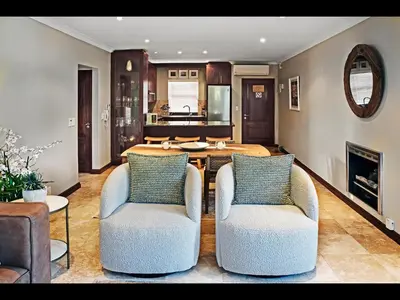 a living room with two chairs and a table at Sorbonne 6 in Franschhoek