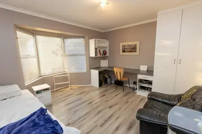 a bedroom with a bed and a desk and a couch at 3 Bedroom part house in the scenic Durbanville wine lands area, holiday facility in Cape Town