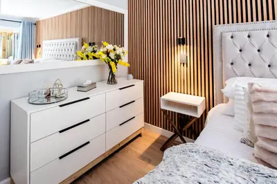 a bedroom with a white dresser and a mirror at Von Chambers Blouberg in Cape Town