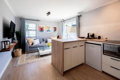 a kitchen and living room with a couch at Von Chambers Blouberg in Cape Town