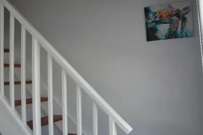 a picture hanging on a wall next to a staircase at 113 Reasons Self Catering in Cape Town