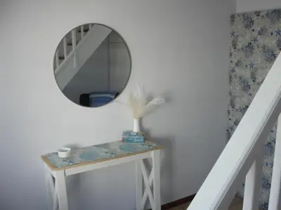 a mirror on a white wall next to a table at 113 Reasons Self Catering in Cape Town