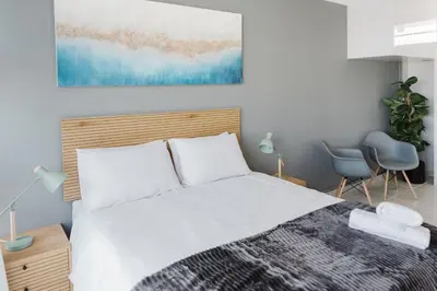 a bedroom with a bed and a painting on the wall at St Tropez Beachfront 108 in Cape Town