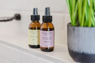 two bottles of essential oils on a shelf next to a vase at St Tropez Beachfront 108 in Cape Town