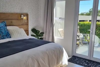 a bedroom with a bed and a sliding glass door at C'est la Vie 5 Garden View Apartment in Franschhoek