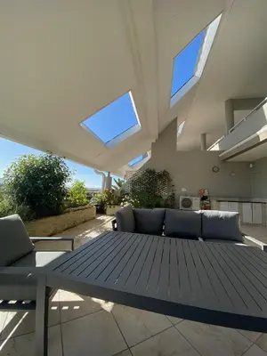 a large living room with a table and skylights at Dolphin Beach Estate 131sm in Cape Town