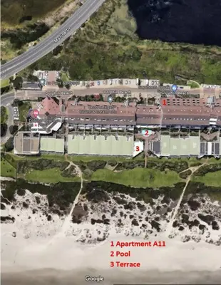 an aerial view of a resort with a road and the ocean at Dolphin Beach Estate 131sm in Cape Town