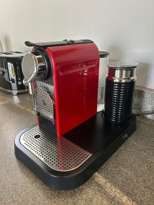 a red coffee maker with a cup on a counter at Zeven Eike Homestead in Stellenbosch