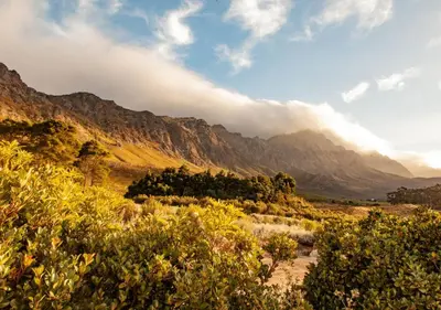 a view of a mountain range with clouds in the sky at Wildeberg Dam House Cottage in Franschhoek