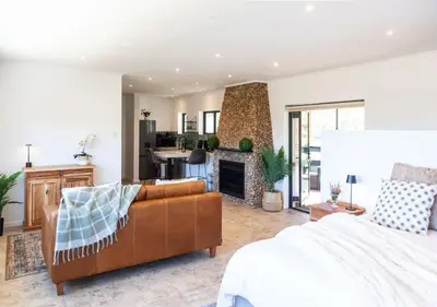 a living room with a couch and a fireplace at Wildeberg Dam House Cottage in Franschhoek