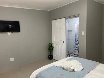 a bedroom with a bed and a tv on the wall at Maita Guest in Cape Town
