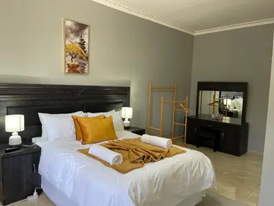 a bedroom with a large white bed with two lamps at Maita Guest in Cape Town