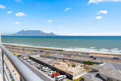 a view of the beach and the ocean from a balcony at The Bay A602 in Cape Town