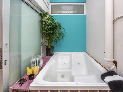 a white bath tub in a bathroom with a plant at Haus Michau in Strand