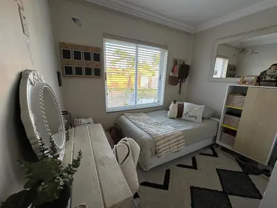 a bedroom with a bed and a window at Strand Holiday home in Cape Town