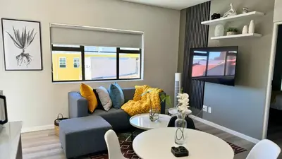 a living room with a blue couch and a tv at Obs Centre Twin Peaks in Cape Town