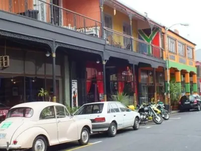 a white car parked in front of a building with motorcycles at Obs Centre Luxe Loft in Cape Town