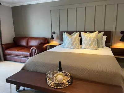 a bedroom with a large bed and a couch at The Cliff Villa Boutique Guesthouse in Hermanus