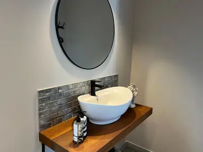 a bathroom with a white sink and a mirror at The Cliff Villa Boutique Guesthouse in Hermanus