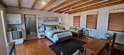 a bedroom with a bed and a couch in it at 8 on Lily Self catering in Cape Town