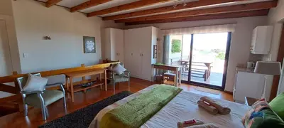 a living room with a table and a dining room at 8 on Lily Self catering in Cape Town