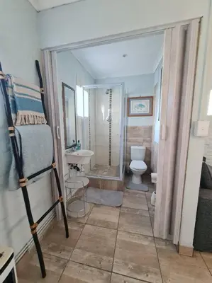 a bathroom with a shower and a toilet and a sink at H & E Sunset Paradise in Fisherhaven