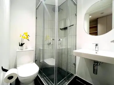 a bathroom with a shower and a toilet and a sink at Seapoint Solace in Cape Town