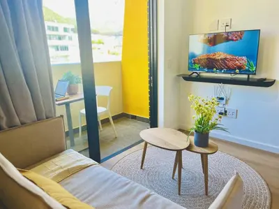 a living room with a couch and a tv and a table at Seapoint Solace in Cape Town