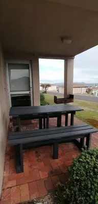 a picnic bench sitting on a brick patio at The Hermanus holiday self catering beach club in Hermanus