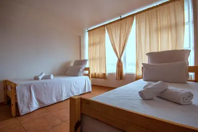 a bedroom with two beds and a large window at Montana Backpackers Cape Town in Cape Town