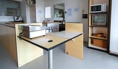 a kitchen with a table with a microwave on it at Montana Backpackers Cape Town in Cape Town