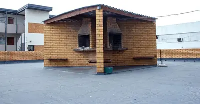 a brown brick building with a roof at Montana Backpackers Cape Town in Cape Town